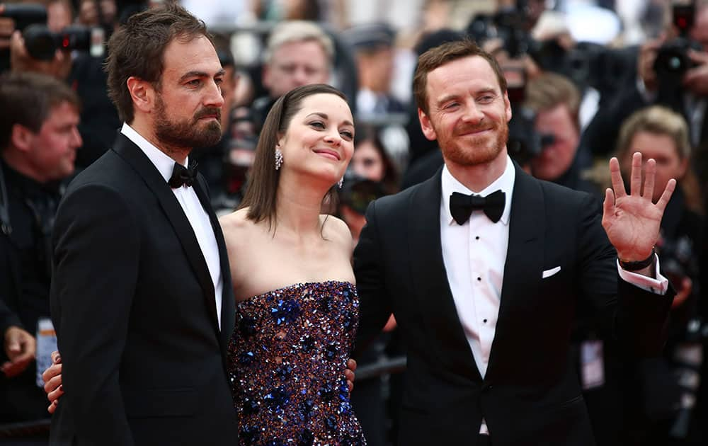 From left, director Justin Kurzel, actors Marion Cotillard, and Michael Fassbender pose for photographers upon arrival for the screening of the film Macbeth at the 68th international film festival, Cannes.