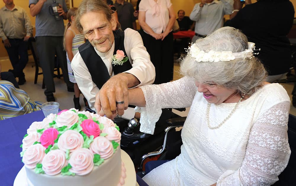 Debbie Rivera, 54, and John Whaley, 58, cut their cake surrounded by friends and family after their wedding ceremony in Green Cove Springs, Fla.