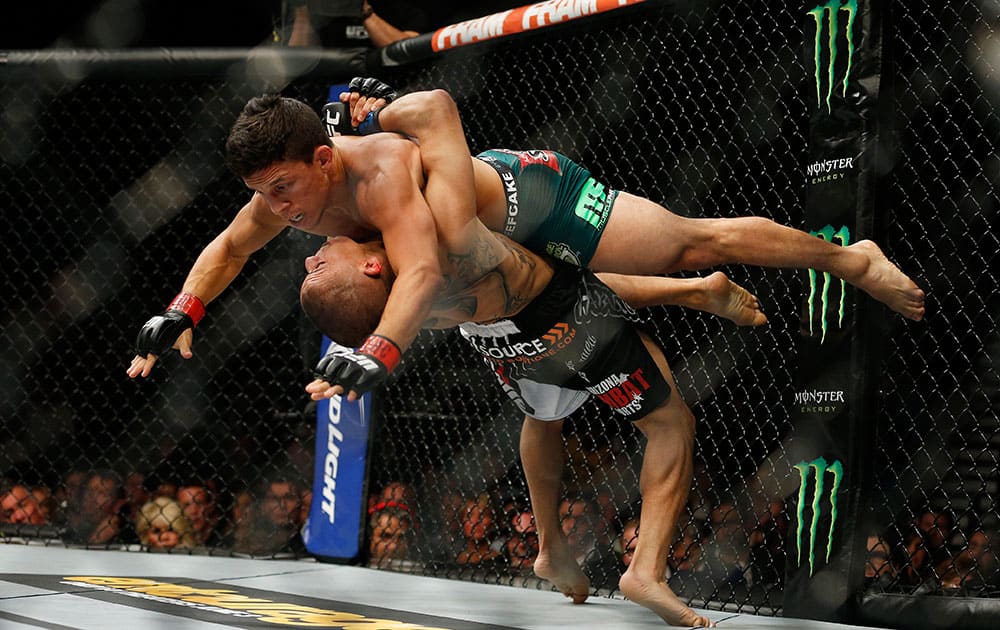 John Moraga, bottom, takes down Joseph Benavidez during their flyweight mixed martial arts bout at UFC 187 in Las Vegas. 