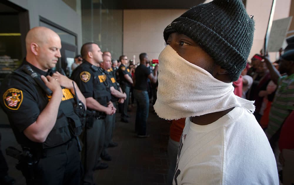 Demonstrators pause at the entrance to the Cuyahoga County Justice Center as police stand guard during a protest against the acquittal of Michael Brelo, a patrolman charged in the shooting deaths of two unarmed suspects, in Cleveland. 