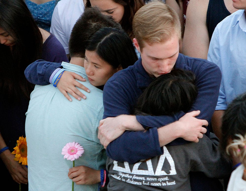 niversity of California, Santa Barbara, students embrace each other during a candlelight vigil held to honor the victims of Friday night's mass shooting, in Isla Vista, Calif. 