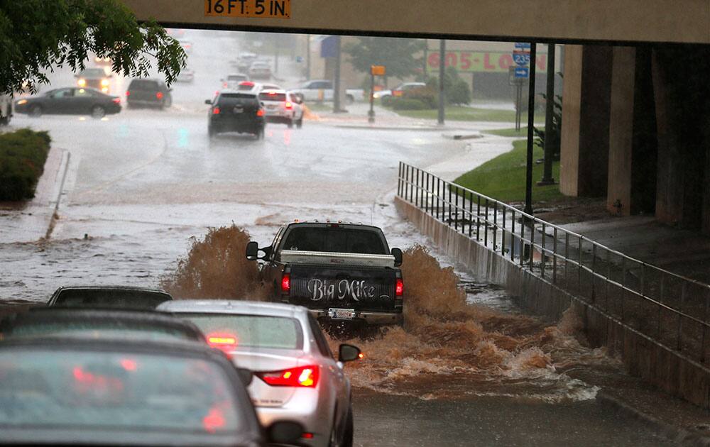 A vehicle tries to cross flood waters in Oklahoma City after storms brought heavy rain.