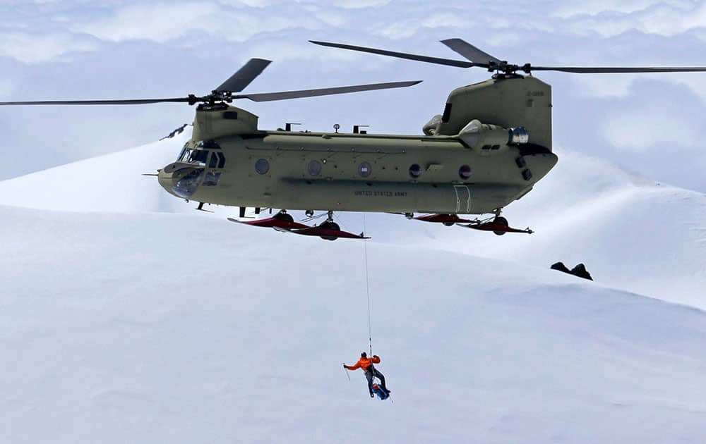a US Army Reserve Boeing CH-47F Chinook helicopter hoists an US Air Force pararescue specialist at about 9,000 feet above sea level.