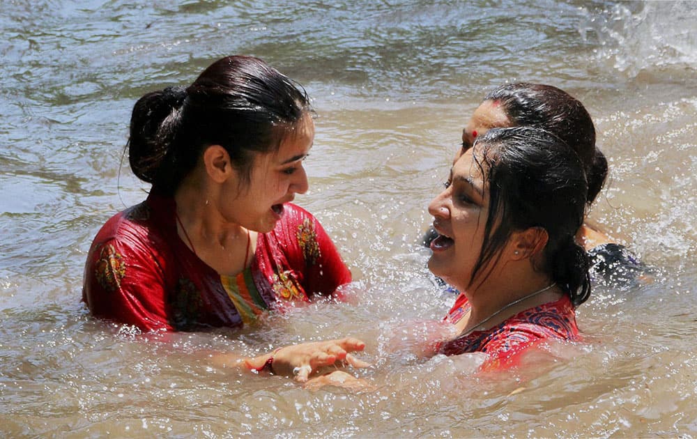 Ladies take a dip in Ranbir Canal to beat the heat on a hot day in Jammu.
