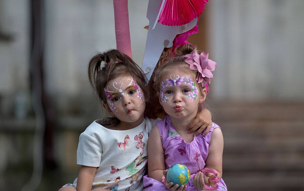 Moldovan pose while being photographed by their mothers during a street musical event in Chisinau, Moldova.