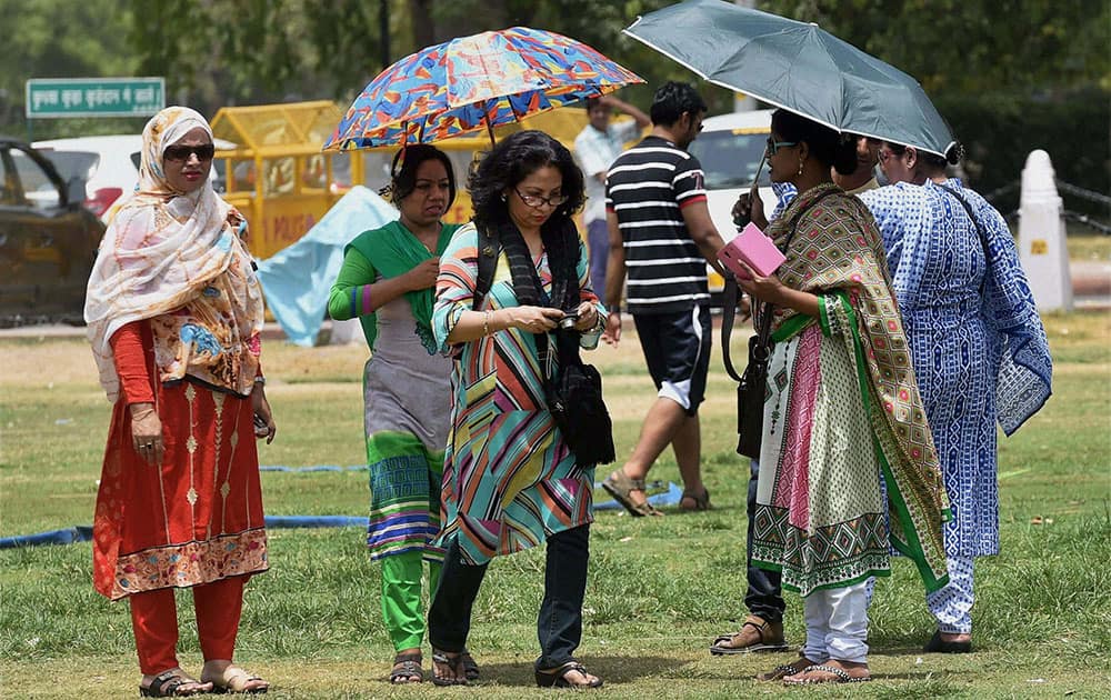 Tourists trying to protect themselves from scorching heat in New Delhi.