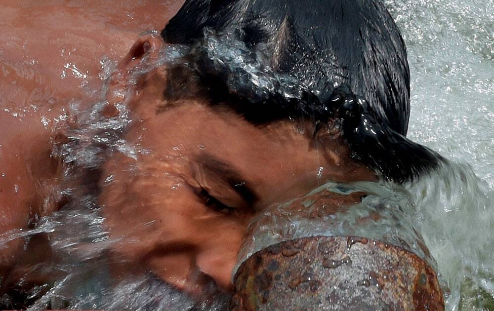 A boy enjoying the splash of water on his face on a hot day.