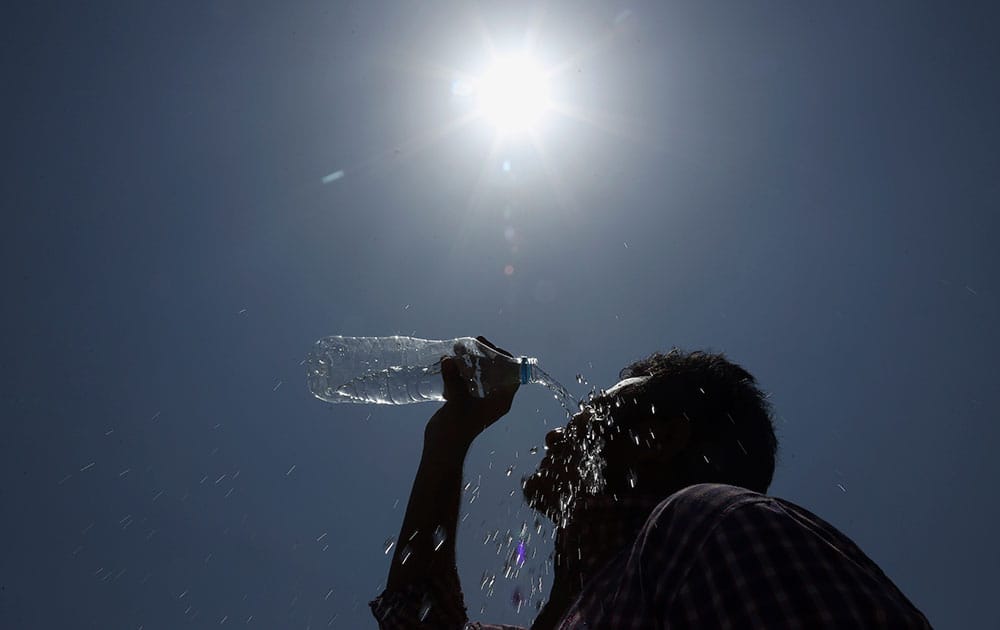 A man pours water on his face during a hot summer day in Hyderabad, India.