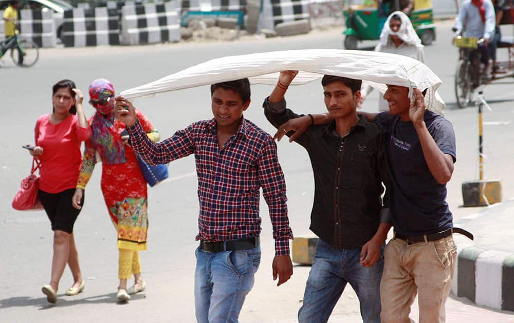 People cover their faces to beat the heat on a hot day in Gurgao..