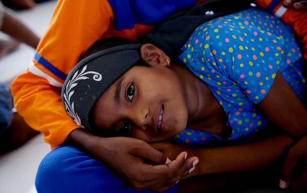 Rohingya migrant Untas Begum rests on the lap of her brother, Mohammad Aesop at a temporary shelter in Kuala Cangkoi, Aceh Province, Indonesia.