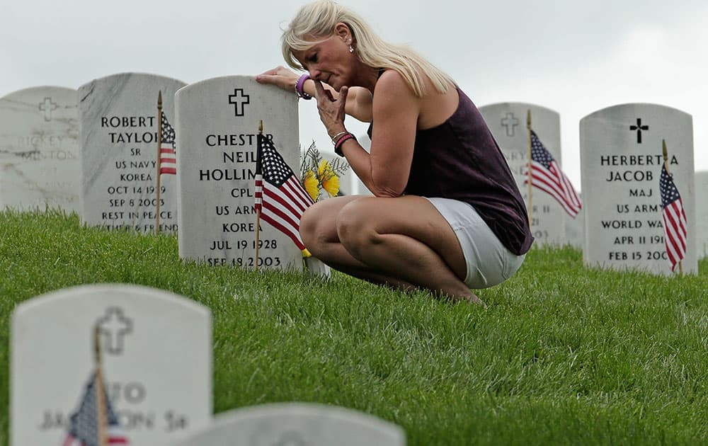 Mary Vanderpool pauses at her parents' grave at the Leavenworth National Cemetery on Memorial Day, in Leavenworth, Kan. 