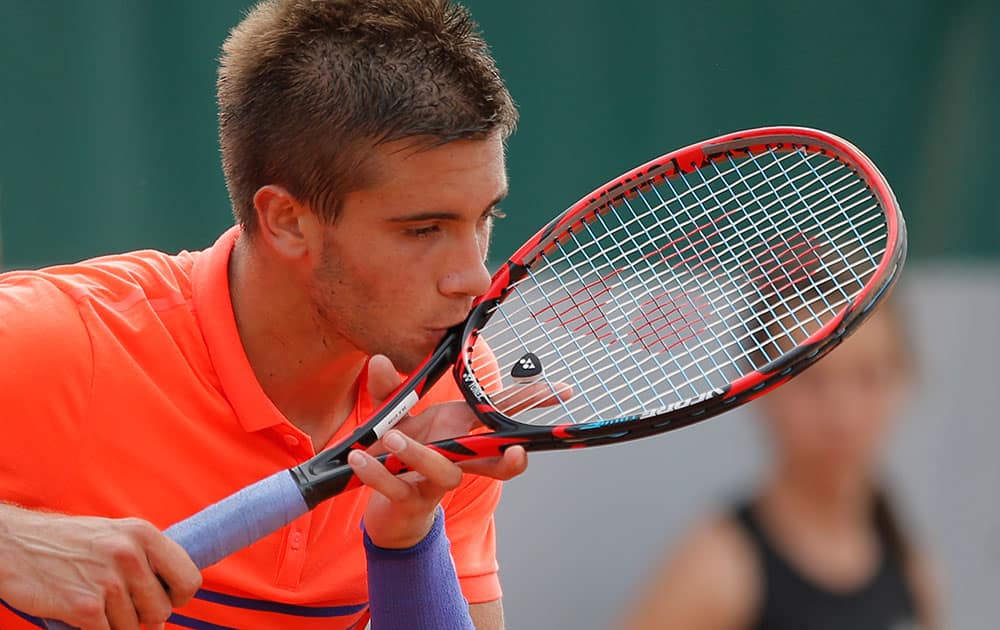 Croatia's Borna Coric kisses his racket in the first round match of the French Open tennis tournament against Sam Querrey of the US.