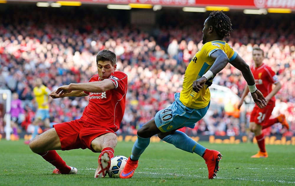 Liverpool's Steven Gerrard, left, challenges Crystal Palace's Pape N'Diaye Souare during the English Premier League soccer match between Liverpool and Crystal Palace at Anfield Stadium, Liverpool, England.