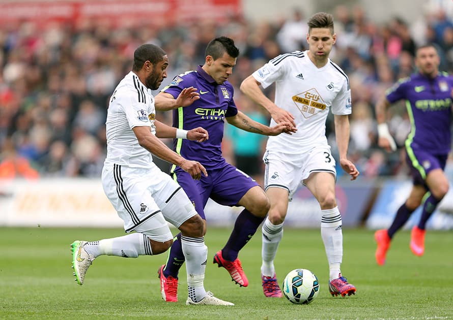 Manchester City's Sergio Aguero, center, battles for the ball with Swansea City's Ashley Williams, left, and Federico Fernandez during their English Premier League soccer match at the Liberty Stadium, Swansea, Wales.