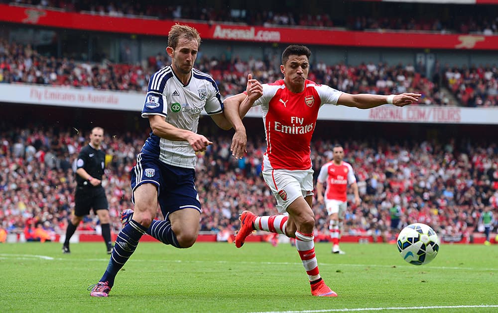 Arsenal's Alexis Sanchez, right, and West Bromwich Albion's Craig Dawson battle for the ball during the English Premier League soccer match at the Emirates Stadium, London.