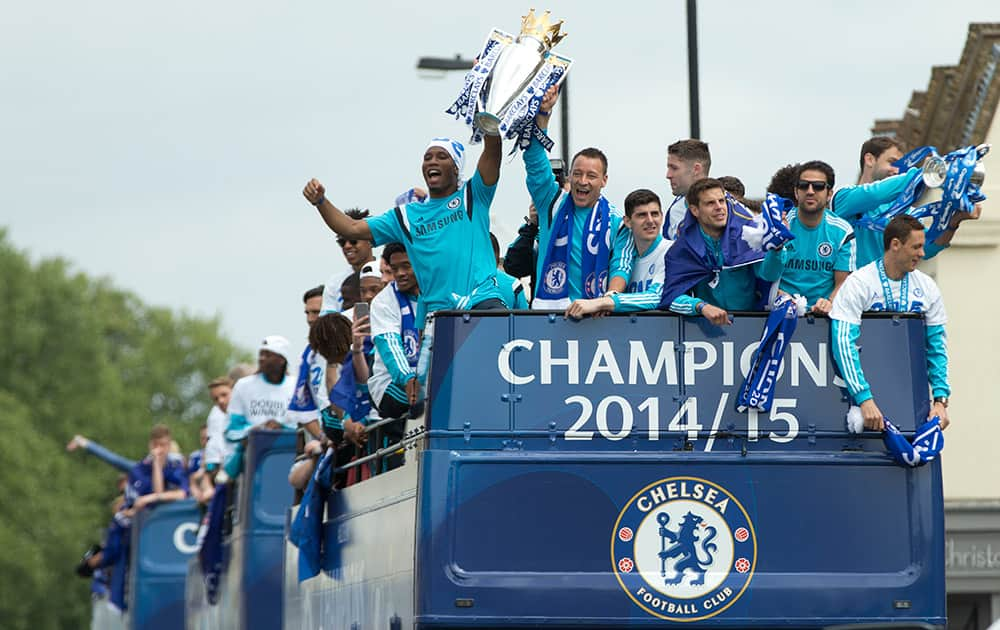 Chelsea's Didier Drogba, front left, holds up the English Premier League trophy with teammate John Terry as the team parade through the streets near their Stamford Bridge stadium in London.