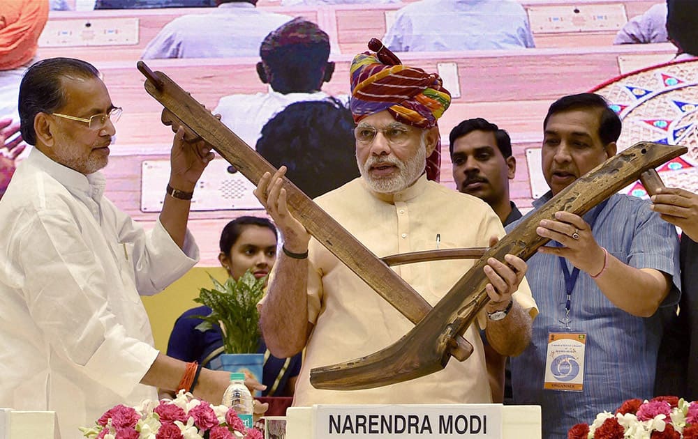 Prime Minister Narendra Modi being presented a model of plough by Agriculture Minister Radha Mohan Singh during the launch of the DD Kisan Channel at Vigyan Bhawan in New Delhi.