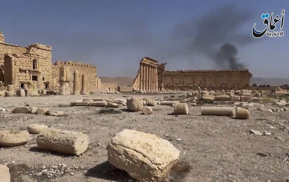 In this image made from a militant video posted on YouTube, which has been verified and is consistent with other AP reporting, smoke rises behind archaeological ruins in Palmyra, Syria.