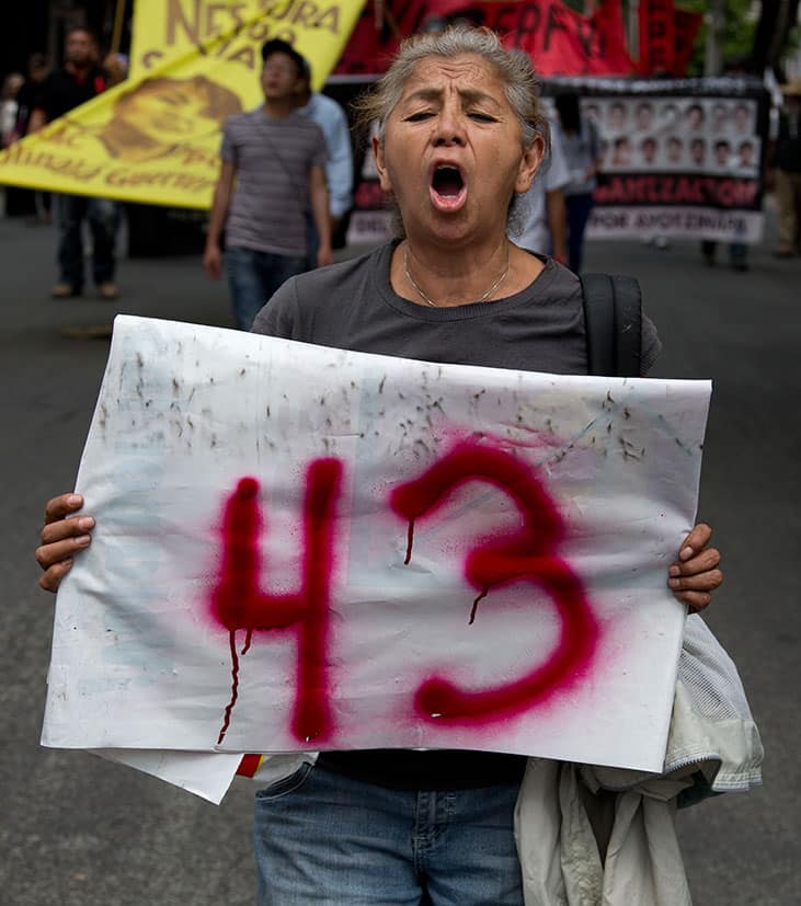 A woman holds a sign with the number 43 in reference to the missing students from a rural teachers college, during march marking the eigth month since their disappearance, in Mexico City.