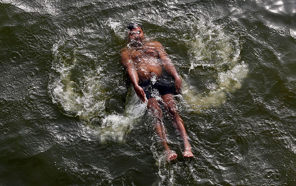 A man swims in the River Yamuna on a hot summer day in Allahabad, India.