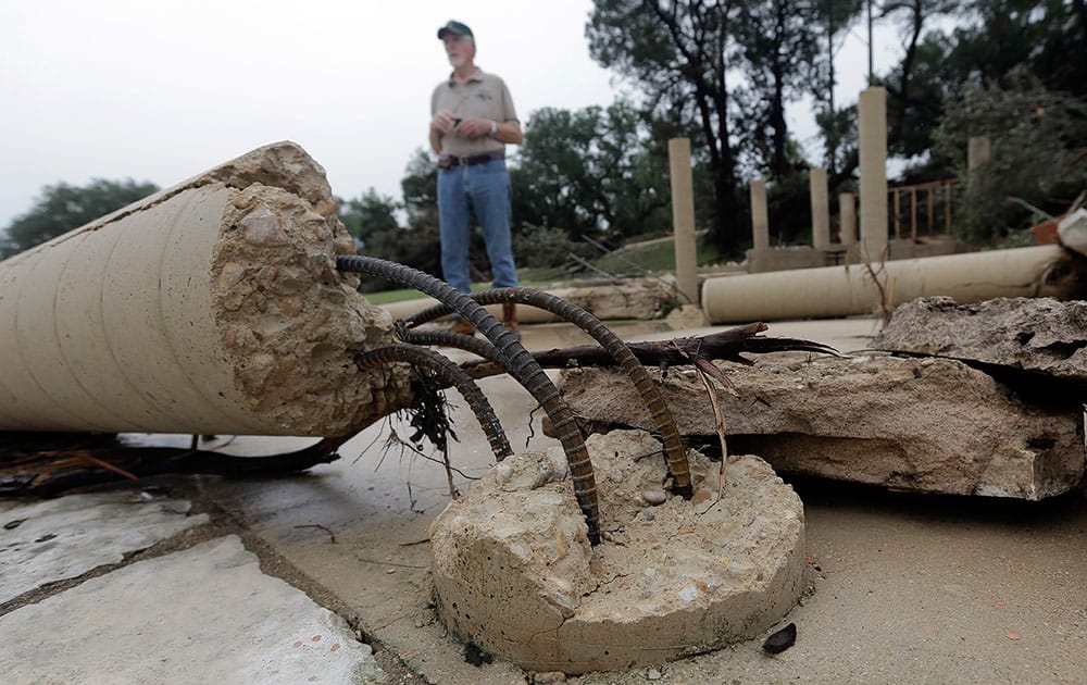 Joel Venable examines the remains of a friend's vacation home that was swept down the swollen Blanco River, in Wimberley, Texas.