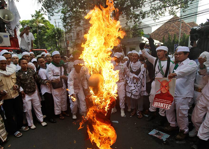 Indonesian Muslim protesters burn a mannequin representing Myanmar's radical Buddhist monk Ashin Wirathu during a protest demanding an end to the violence against ethnic Rohingyas in Rakhine State, outside the Embassy of Myanmar in Jakarta, Indonesia.