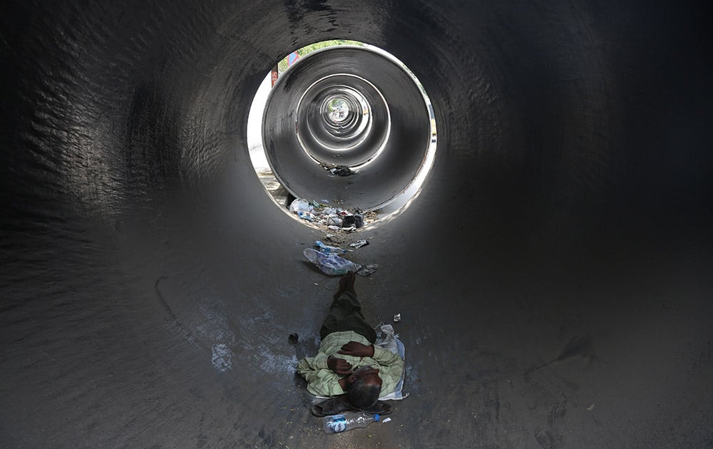 A man rests inside a concrete pipe on a hot summer day in Hyderabad. Hundreds of people have died in southern India since the middle of April as soaring summer temperatures scorch the country.