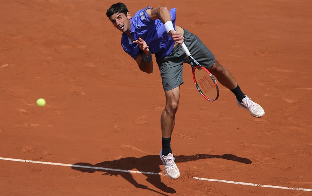 Brazil's Thomaz Bellucci serves in the second round match of the French Open tennis tournament against Japan's Kei Nishikori at the Roland Garros stadium, in Paris, France.