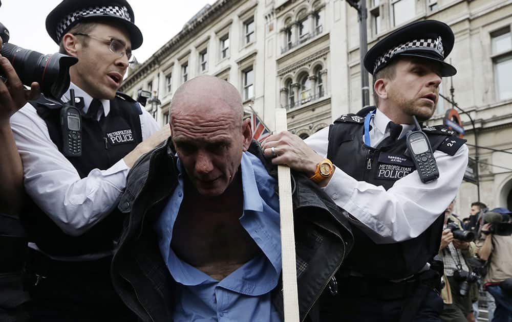 A protester clashes with police during an anti-austerity, anti-Conservative Party protest after the Queen's Speech was delivered to Parliament in London.