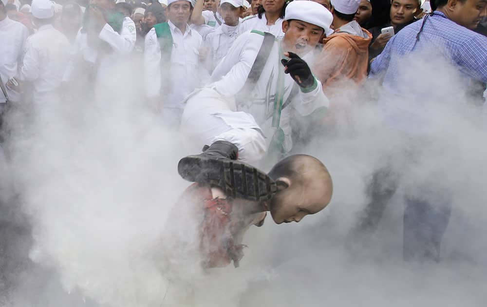 An Indonesian protester kicks a mannequin representing Myanmar's radical Buddhist monk Ashin Wirathu during a protest demanding an end to the violence against ethnic Rohingyas in Rakhine State, outside the Embassy of Myanmar in Jakarta, Indonesia.