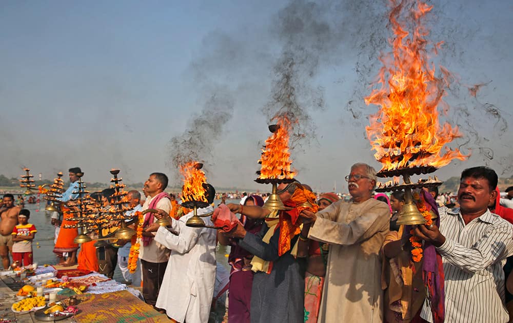 Hindu devotees rotate traditional lamps in circular movement as they perform morning prayers at Sangam, the confluence of the Rivers Ganges, Yamuna and the mythical Saraswati, in Allahabad.