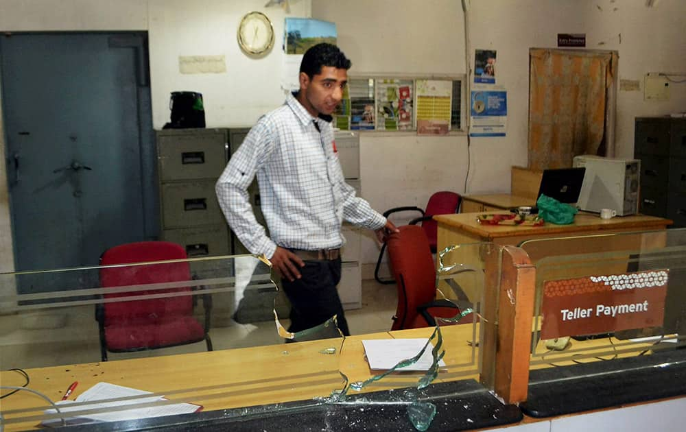 An employee stands at a counter after a firing by militants in a bank at Kachdoora in Shopian district.