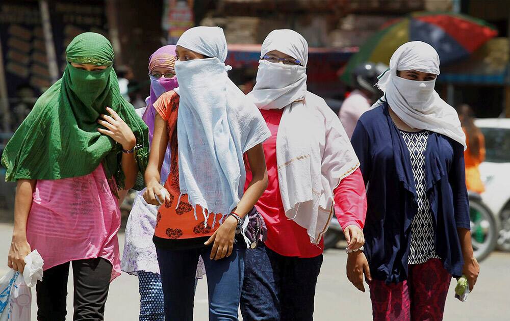 Girls cover their faces to protect themselves from the heat in Allahabad.