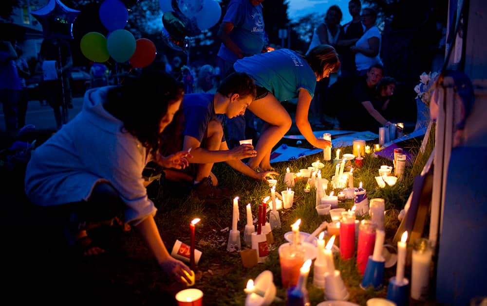 People place candles at a vigil in memory of 5-year-old Mackenzie Maison Friday, May 29, 2015, in Port Huron, Mich. Maison and her 3-year-old sister were found malnourished, dehydrated and abused. 