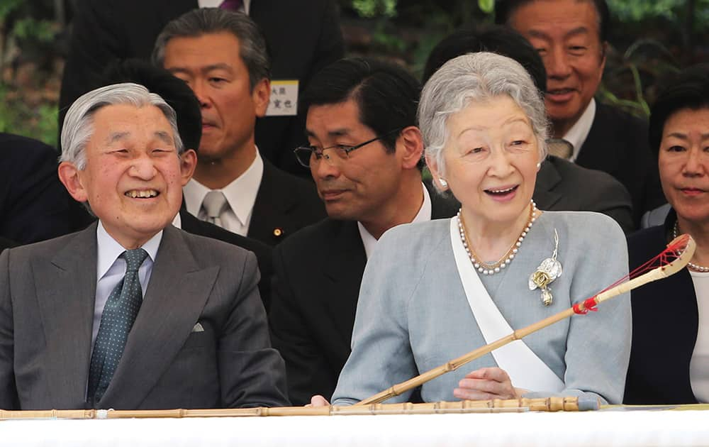 Japanese Emperor Akihito and Empress Michiko enjoy watching a demonstration of the Japanese traditional horsemanship 'dakyu,' the ancient Japanese lacrosse on horseback, while holding a 'kyujo,' a racket for dakyu, at the Imperial Palace in Tokyo.