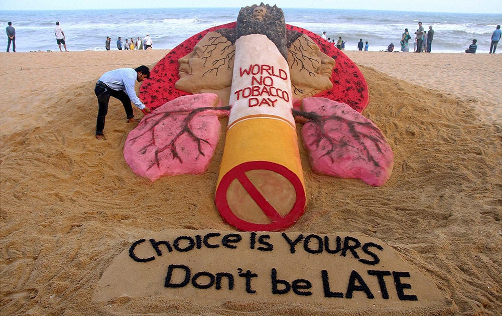 Sand artist Sudarsan Pattnaik creates a sand sculpture with a message 'Choice is Yours, Don’t be Late' on the eve of World No-tobacco Day.