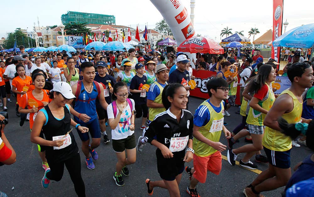 Participants run at the start of an international half marathon in Phnom Penh, Cambodia.