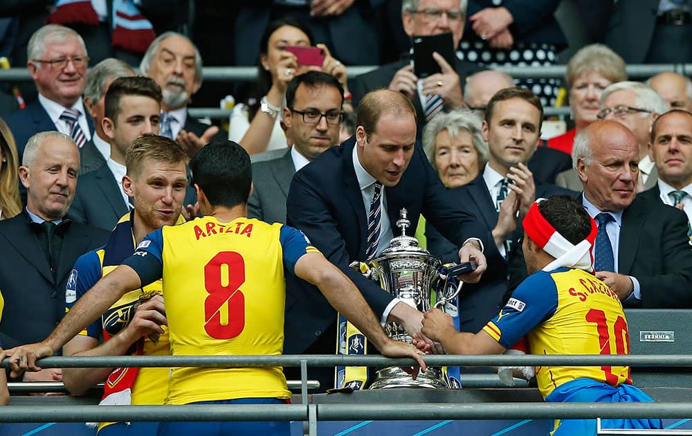 Britain's Prince William hands a winners medal to Arsenal's Santi Cazorla after the English FA Cup final soccer match between Aston Villa and Arsenal at Wembley stadium in London.