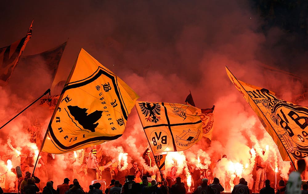 Dortmund supporters light flares during the German soccer cup final match between Borussia Dortmund and VfL Wolfsburg in Berlin, Germany.