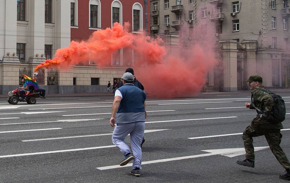 Russian anti-gay demonstrators run to attack a quad bike driving by gay rights activists during an attempt to hold a gay demonstration in central Moscow, Russia.