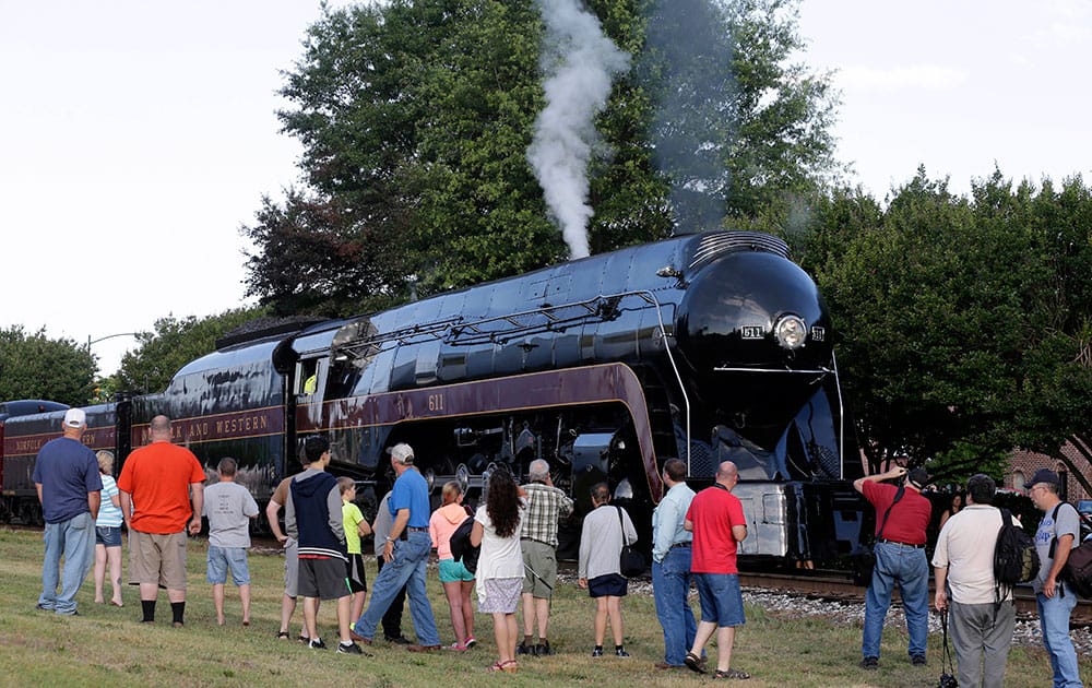 People take photos of the Norfolk & Western Class J No. 611 steam locomotive before it leaves the North Carolina Transportation Museum in Spencer, N.C.