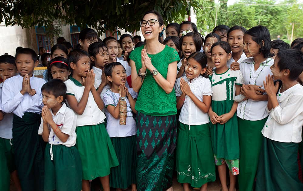 Malaysian actress Michelle Yeoh, center, global ambassador for the Make Roads Safe Campaign, laughs as she poses with orphans for a group photo during her visit to a monastic school in Kaw-Hmu in the outskirts of Yangon, Myanmar.