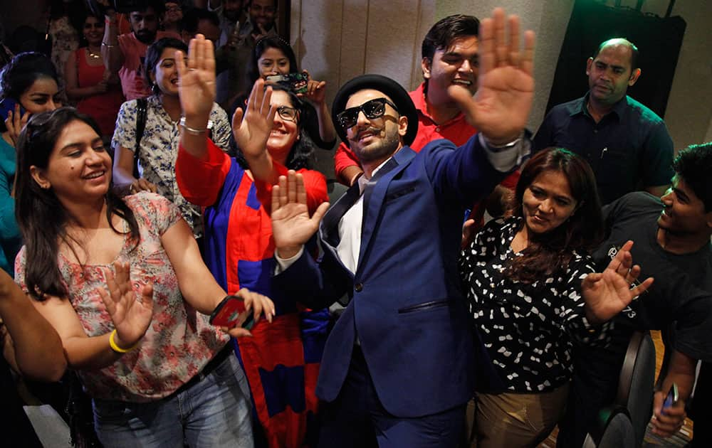 Bollywood actor Ranveer Singh, center, dances with members of the media during a press conference for his upcoming film 