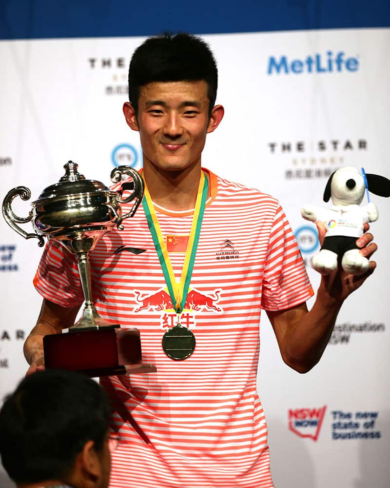 Chen Long of China smiles with his victory medal and trophy after winning his men's singles final against Victor Axelsen of Denmark at the Australian Badminton Open in Sydney.