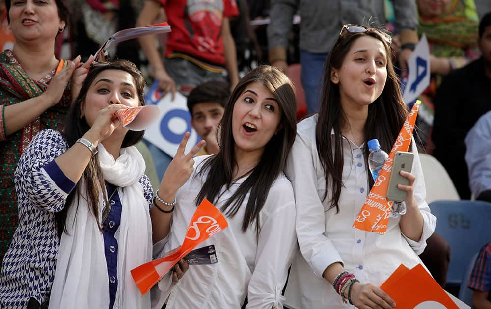 Pakistani cricket fans cheer during the third one-day international match between Pakistan and Zimbabwe at Gaddafi Stadium, in Lahore.