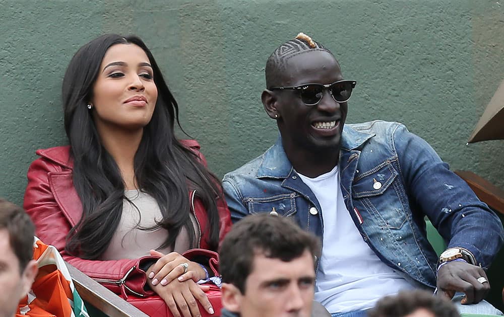 Liverpool French soccer player Mamadou Sakho and his wife Majda watch France's Jo-Wilfried Tsonga playing Tomas Berdych of the Czech Republic during their fourth round match of the French Open tennis tournament at the Roland Garros stadium.