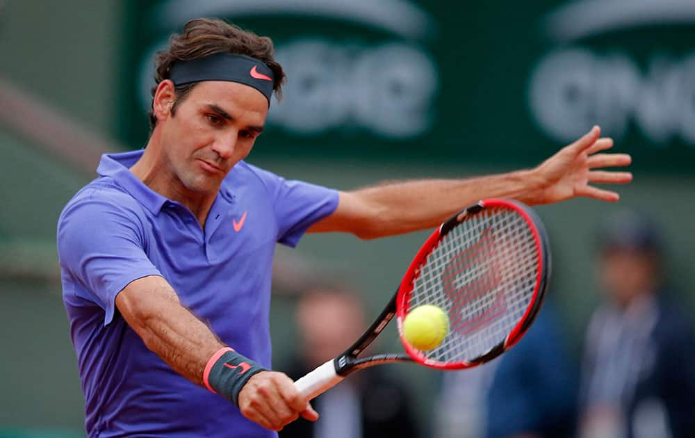 Switzerland's Roger Federer returns the ball to France's Gael Monfils during their fourth round match of the French Open tennis tournament at the Roland Garros stadium.