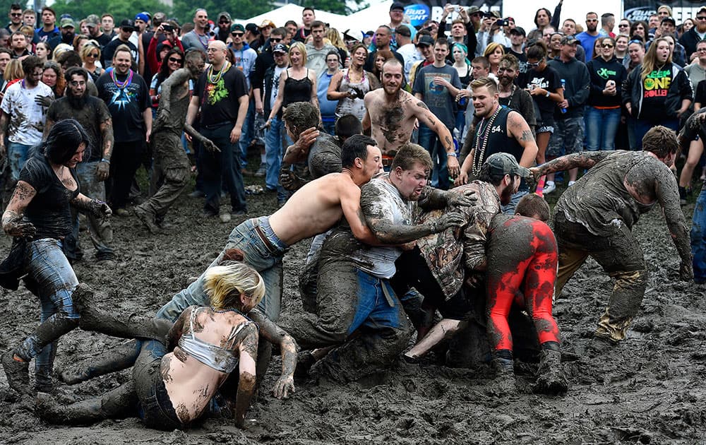 Spectators wrestle in the mud during Rockfest at the Liberty Memorial in Kansas City, Mo.