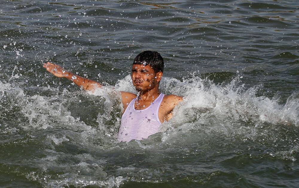 A man jumps into the River Sabarmati to beat the heat on a hot summer day on the outskirts of Ahmadabad, India.