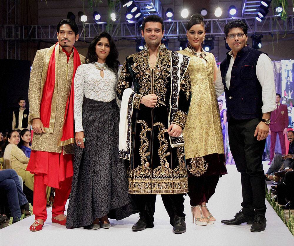 Bollywood actors Shawar Ali, his wife Marsela Ayesha and Mimoh Chakraborty display creation of fashion designers Reshma and Riyaz Gangji during a fashion show in Mumbai.